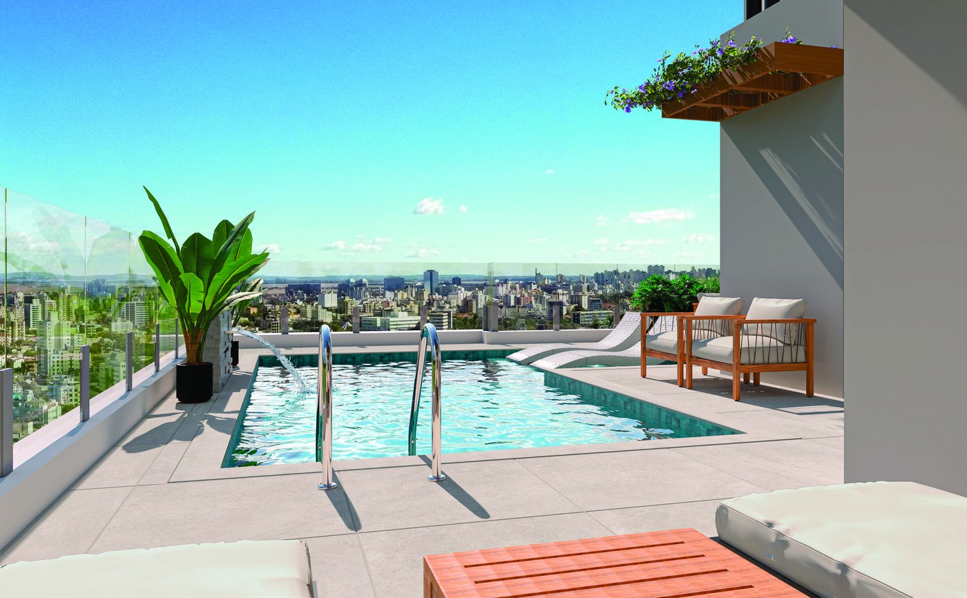 Piscina do rooftop com deck em madeira, espreguiçadeiras e a cidade ao fundo.